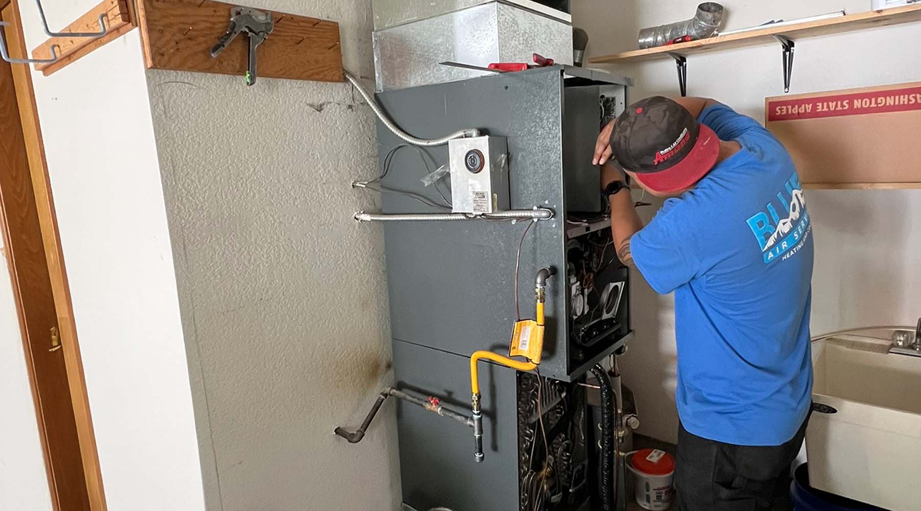 Blues HVAC tech fixing furnace