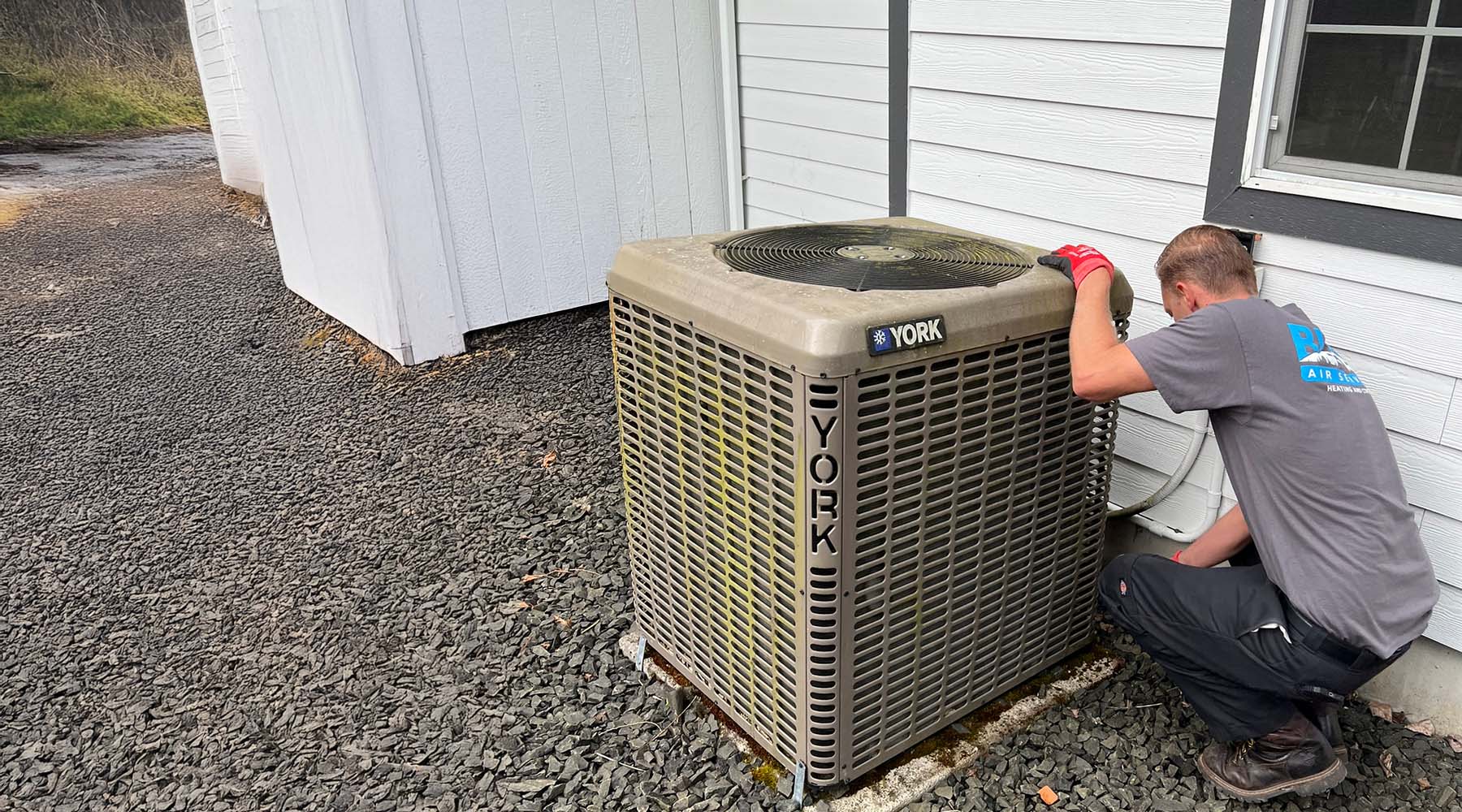 Blues Technician performing maintenance on a York air conditioning unit