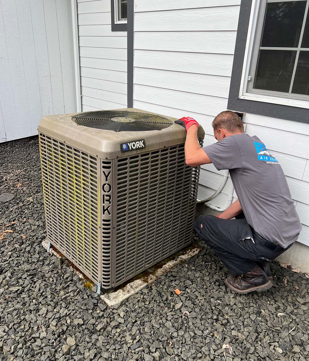 Blues Technician performing maintenance on a York air conditioning unit