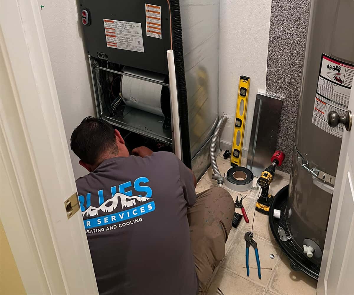 Blues HVAC technician. installing furnace