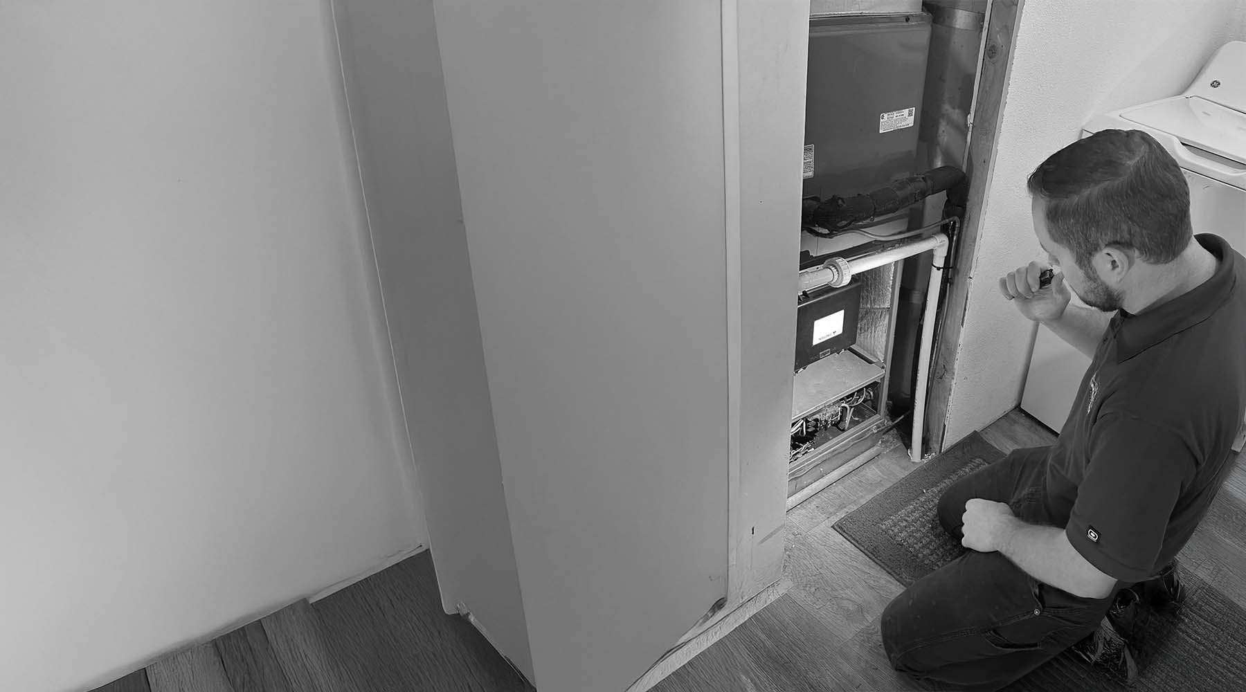 Close-up of a technician inspecting a furnace for issues.